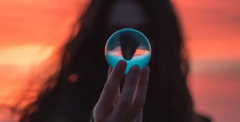 Ragazza riflessa nella sfera al tramonto